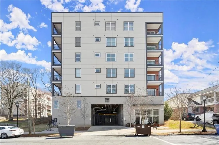 Modern multi-story building featuring a light-toned facade and multiple private balconies