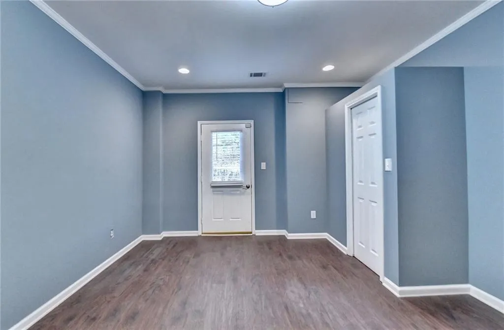 Basement Bedroom Entrance foyer featuring dark wood-style floors, ornamental molding, baseboards, and recessed lighting