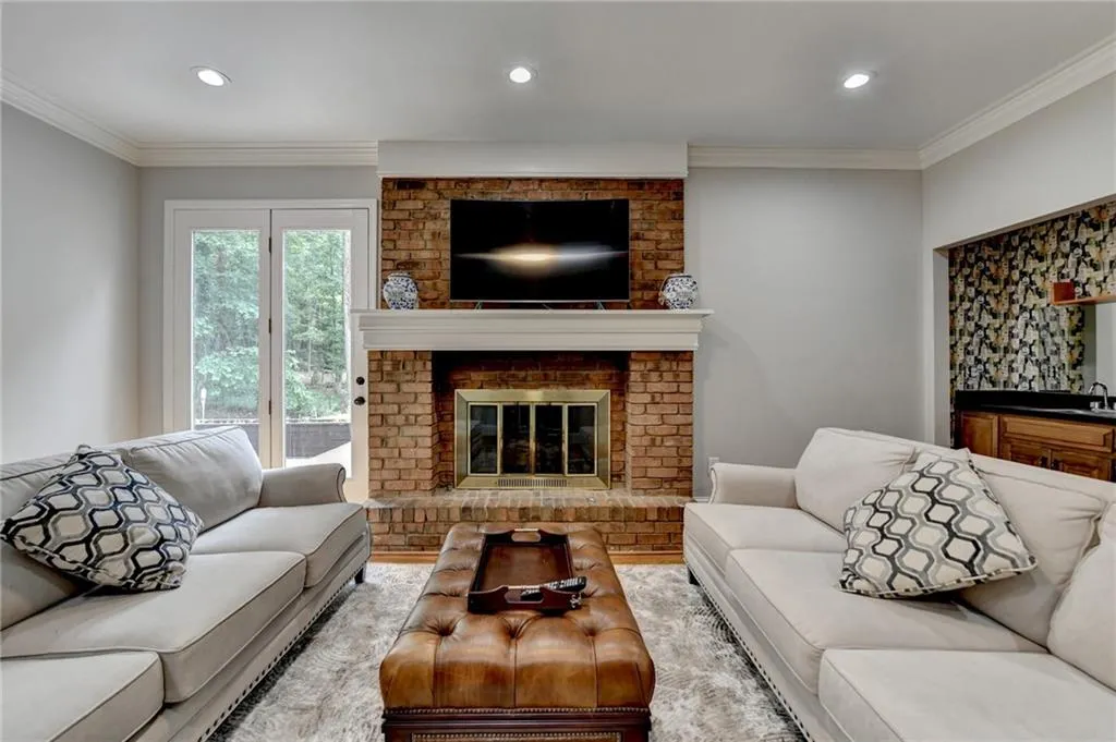 Living area featuring crown molding, recessed lighting, and a fireplace