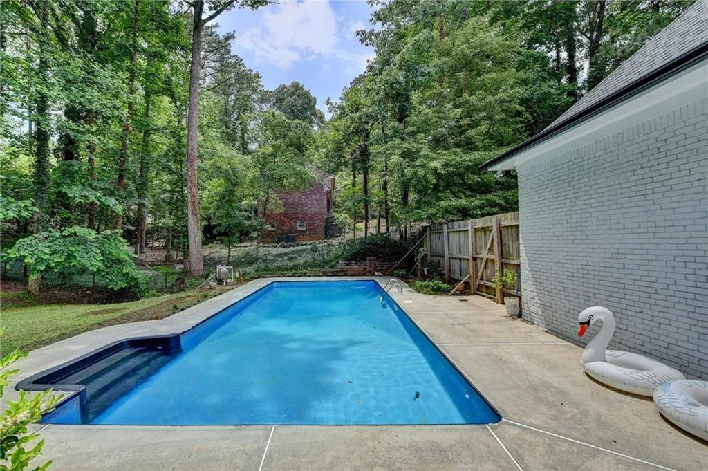 View of swimming pool featuring a patio area and view of scattered trees