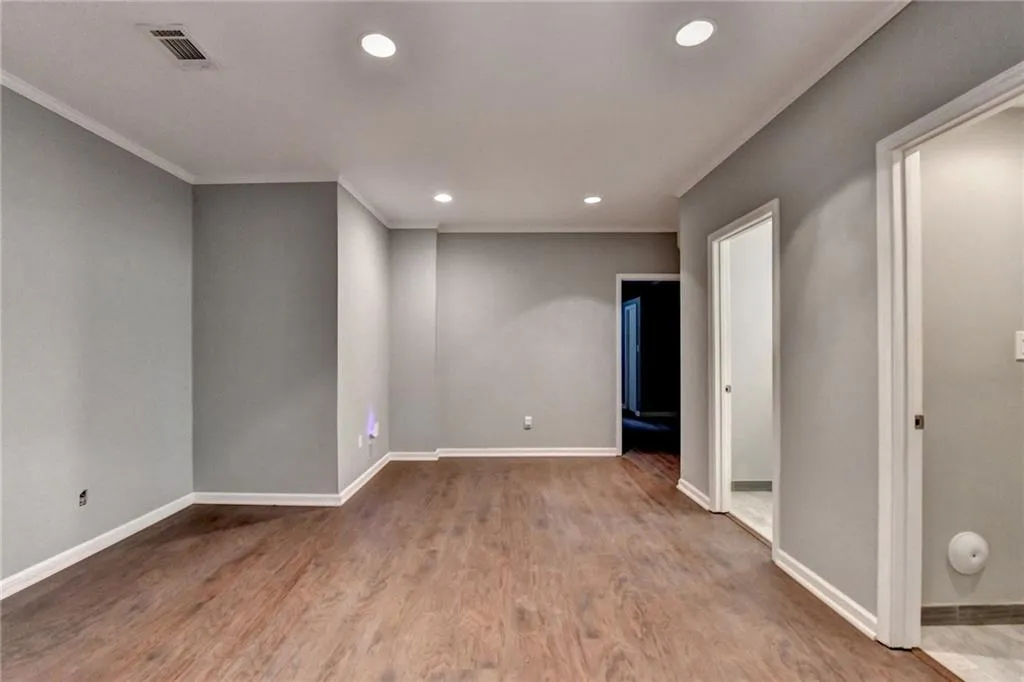 Basement Open Space crown molding, wood finished floors, recessed lighting, and baseboards