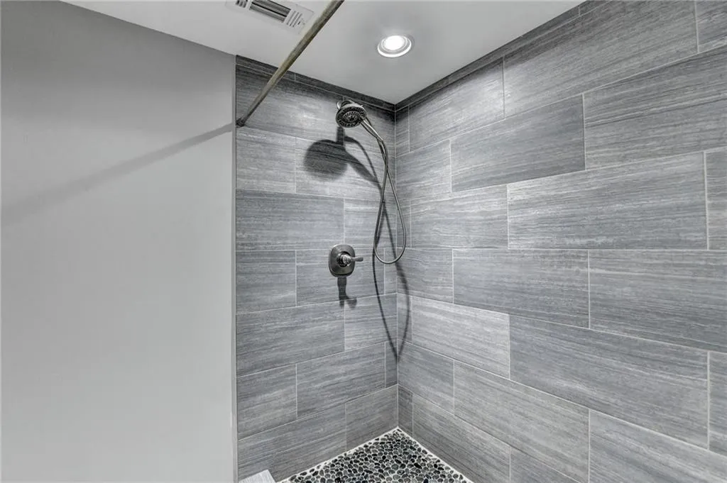 Basement Bathroom featuring a tile shower