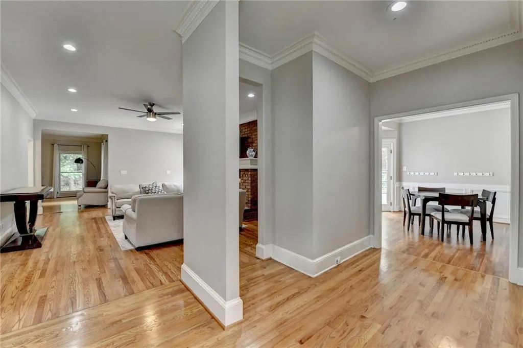Hallway with ornamental molding, light wood finished floors, recessed lighting, and baseboards
