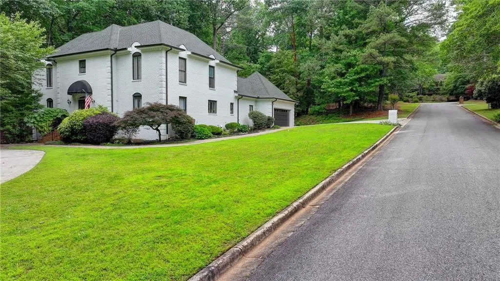View of front facade featuring a front yard, a garage, and view of scattered trees
