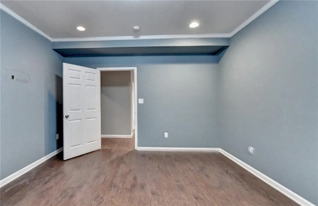 Basement Bedroom featuring crown molding, baseboards, wood finished floors, recessed lighting, and a smoke detector