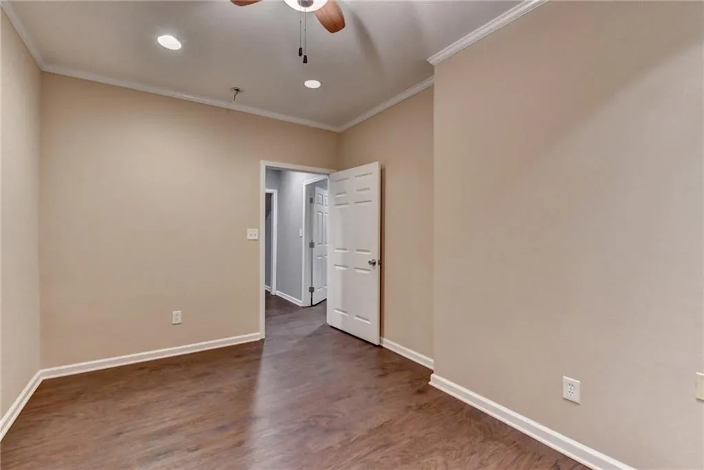 Basement Unfurnished room with ornamental molding, a ceiling fan, baseboards, wood finished floors, and recessed lighting