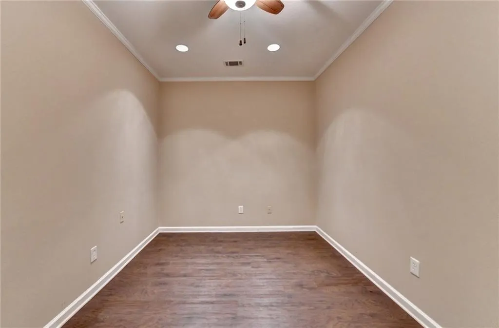 Basement Spare room featuring a ceiling fan, ornamental molding, baseboards, dark wood finished floors, and recessed lighting