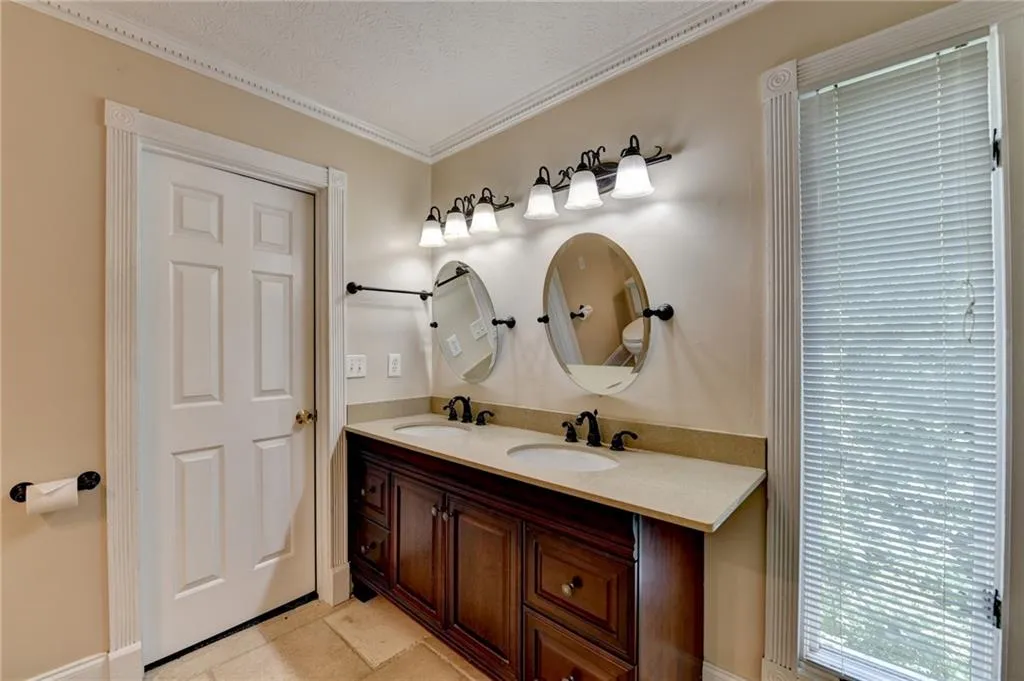 Full bath featuring ornamental molding and double vanity
