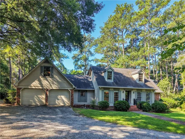 Traditional-style residence featuring light-colored siding and a dark shingle roof