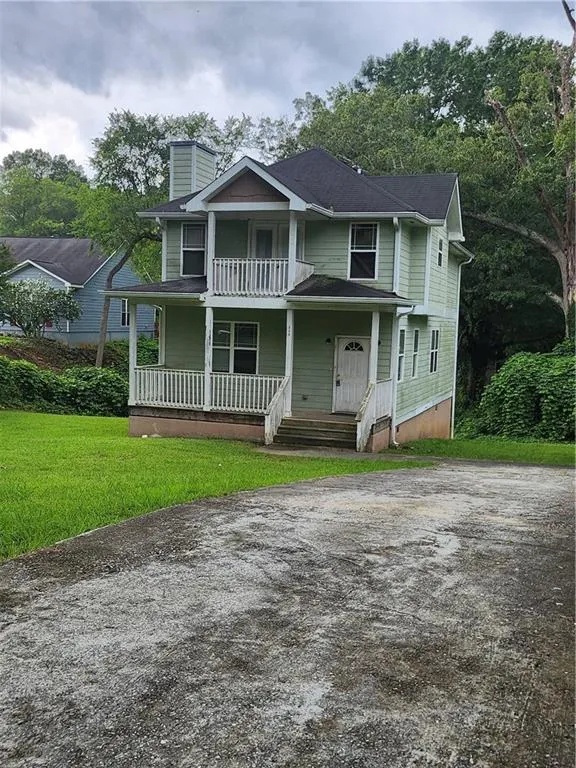 View of front facade featuring a porch, driveway