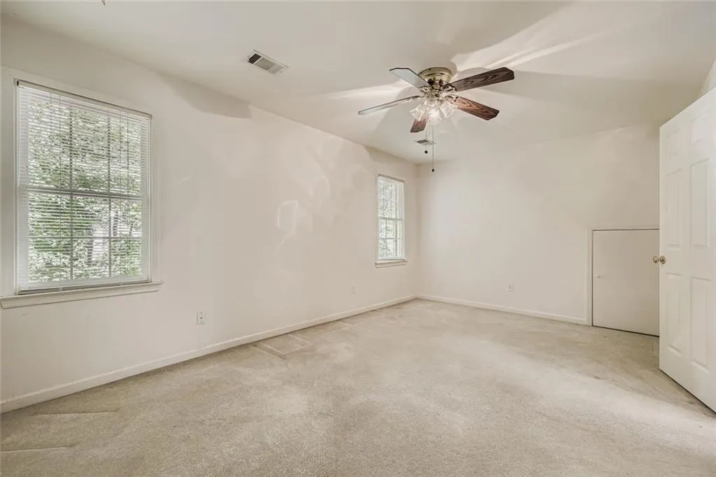 Unfurnished room featuring light colored carpet and ceiling fan