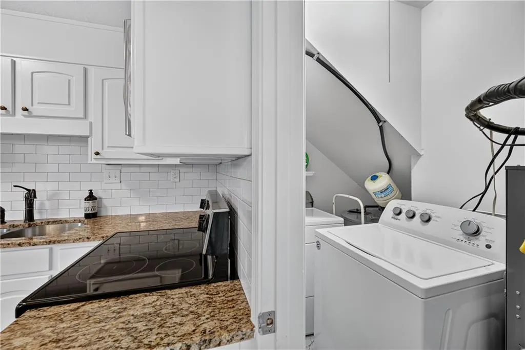Kitchen featuring white cabinetry, subway tile backsplash, stone-finish countertops, and an electric cooktop