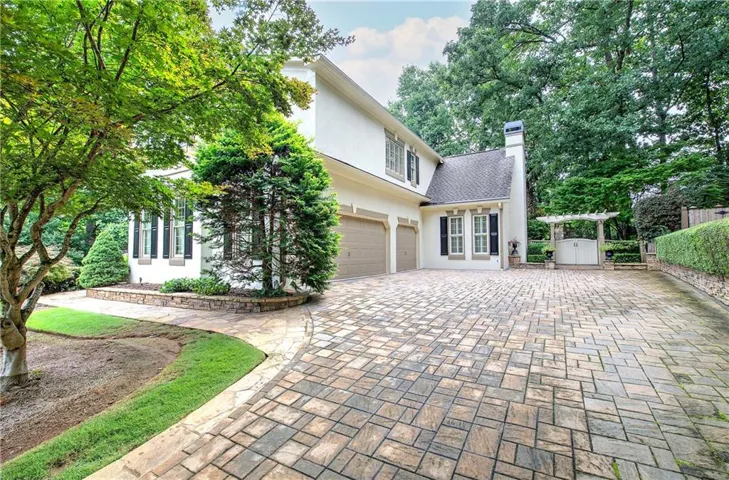 3 car garage, stone driveway, gate entrance to backyard