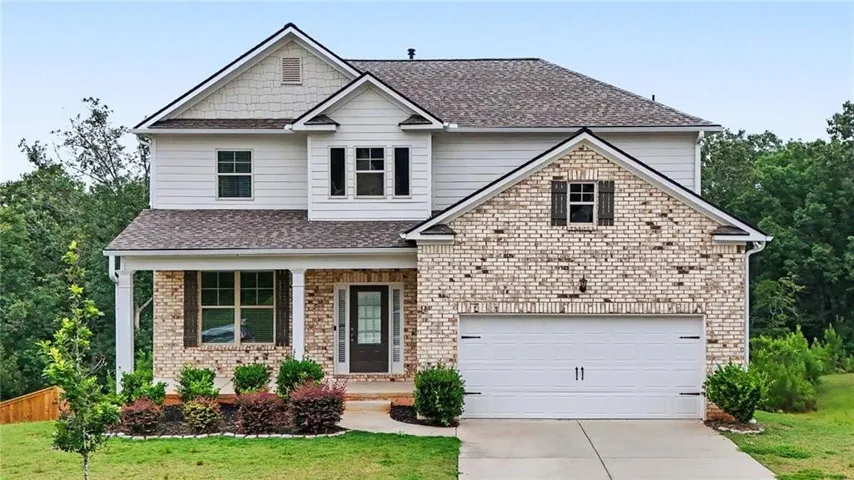 Two-story residence featuring light brick and horizontal siding