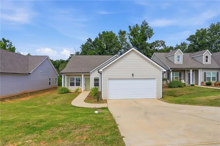 Ranch-style exterior with light-toned siding and a two-car garage