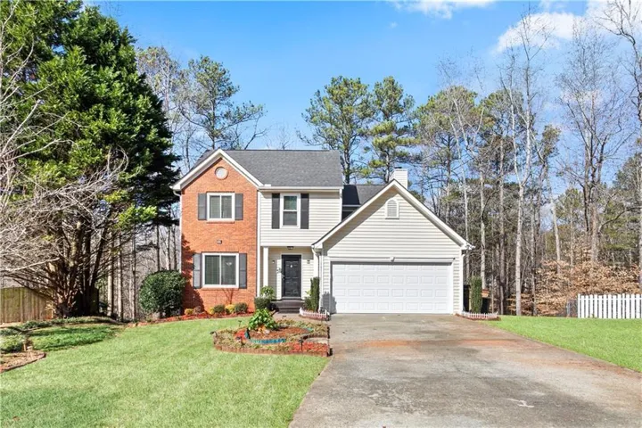 Two-story residence featuring brick and siding exterior, an attached two-car garage, and a concrete driveway