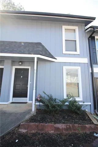 View of exterior entry with roof with shingles