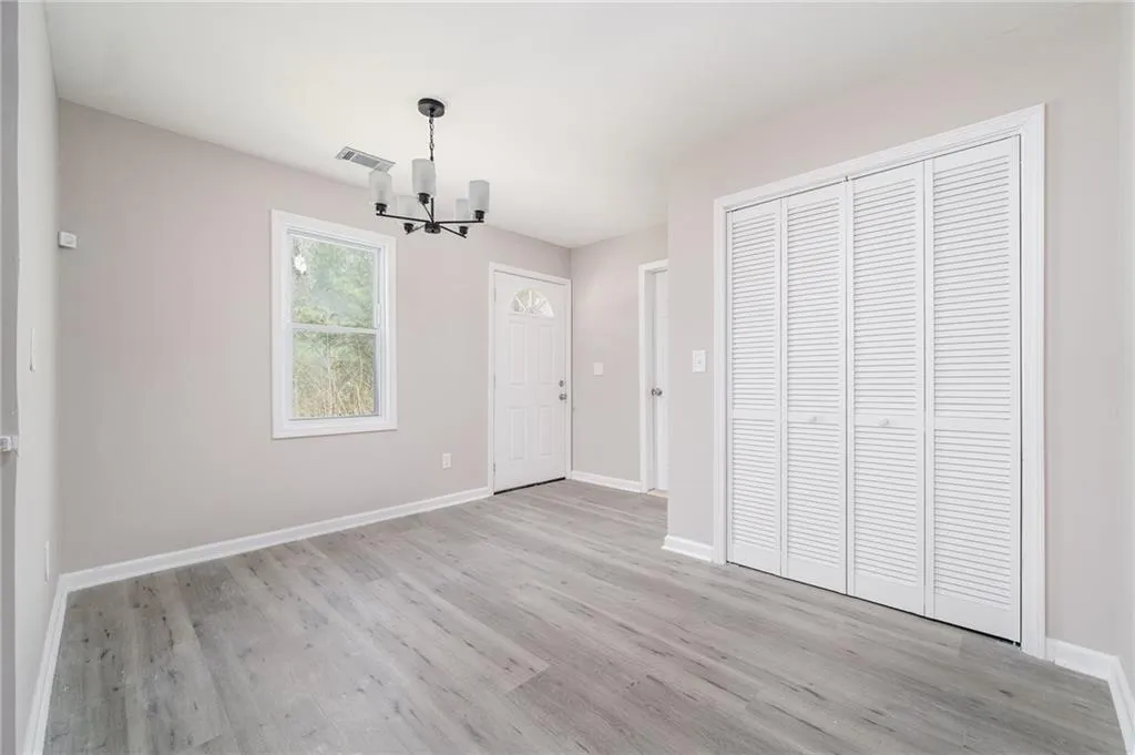 Unfurnished dining area featuring light wood-type flooring and a chandelier