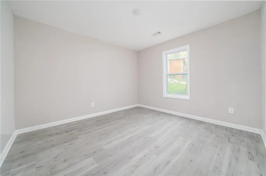 Unfurnished room with light wood-style flooring and baseboards