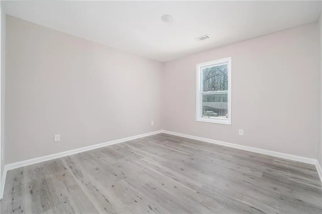 Spare room featuring light wood-style flooring and baseboards