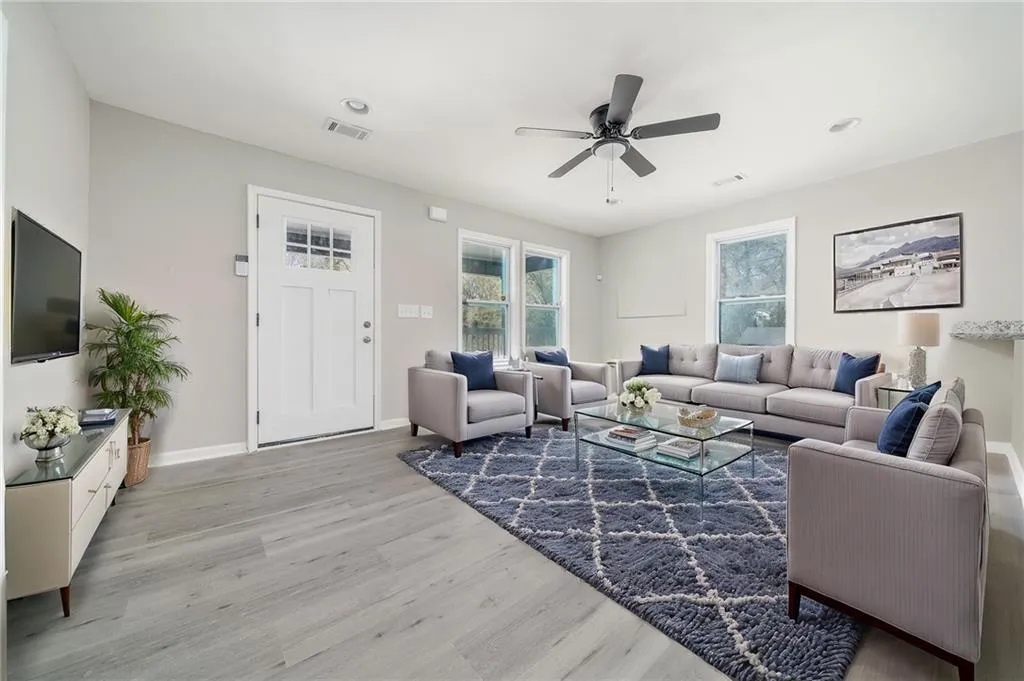 Living area with light wood-style flooring and a ceiling fan