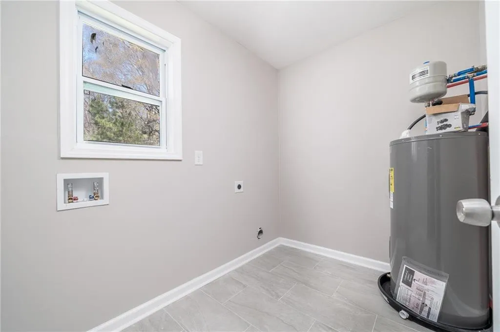 Laundry room featuring electric dryer hookup, electric water heater, and hookup for a washing machine