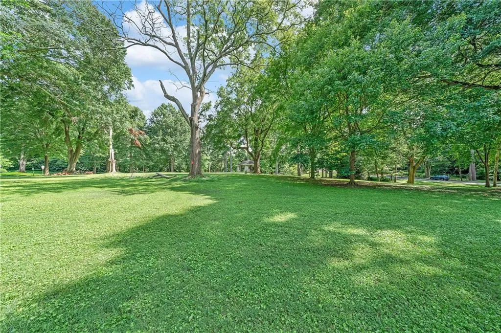 Expansive green lawn surrounded by mature trees