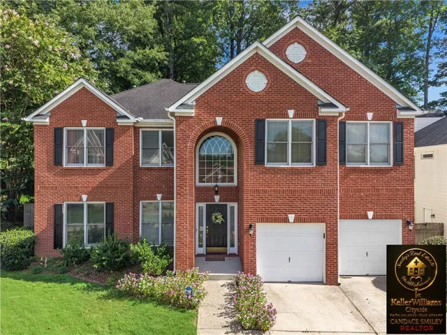 Stately brick Colonial featuring a two-story facade with symmetrical architectural detailing, arched entry door with transom window, and multiple multi-pane windows