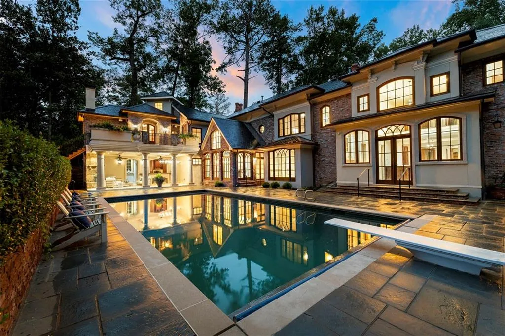 Brick and stucco exterior featuring multiple arched windows and a covered patio with pillars