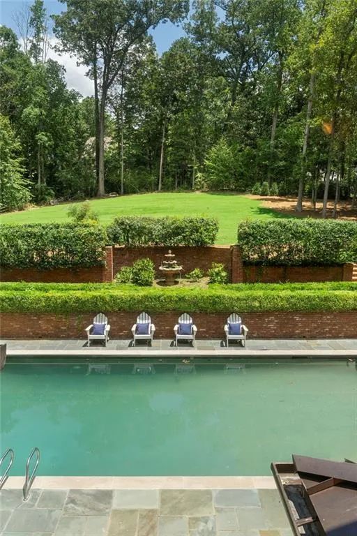 Swimming pool with stone surround and stainless steel handrails