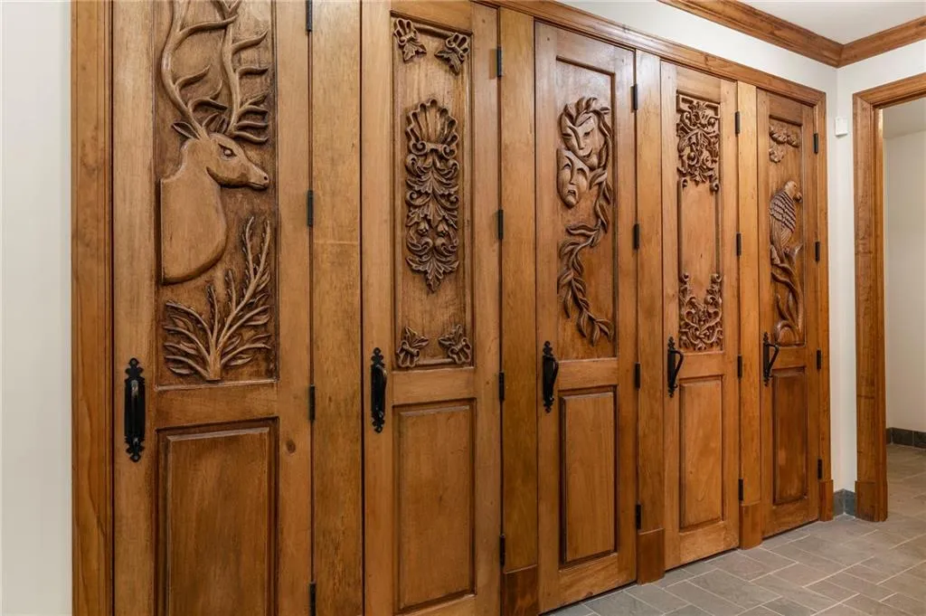 Custom carved wood-finish bi-fold doors with black hardware, featuring a range of intricate designs
