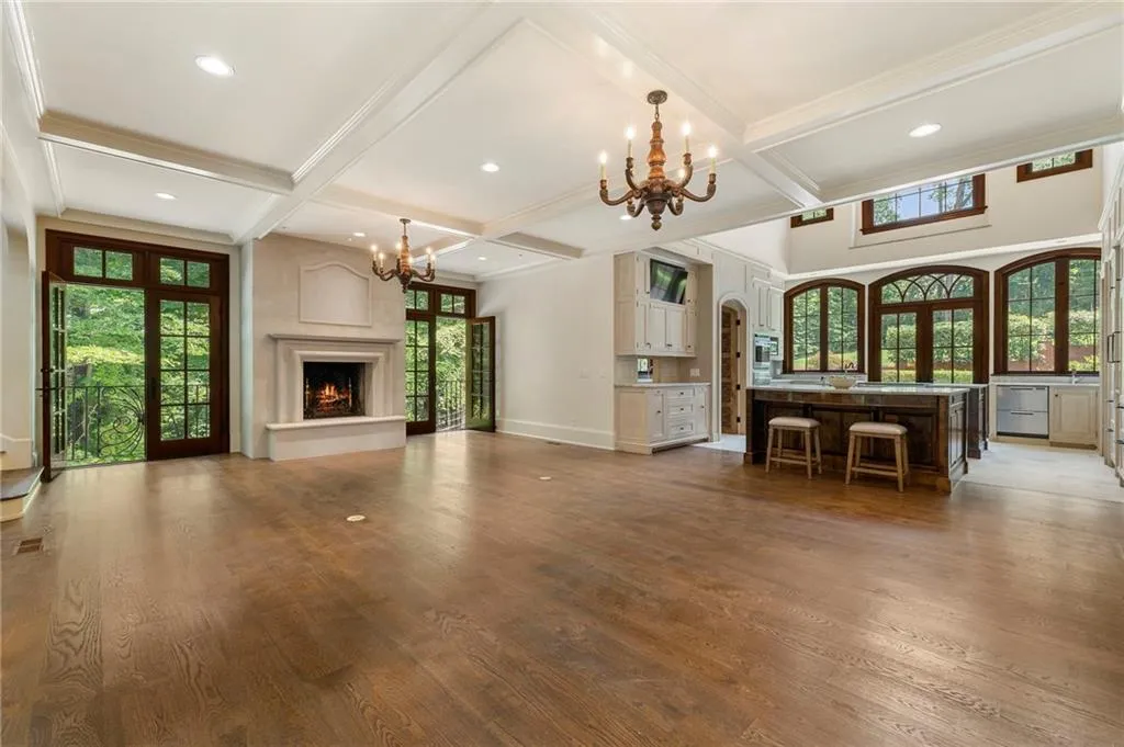 Spacious interior featuring wood-finish flooring, a decorative fireplace with mantel, and exposed beam ceilings