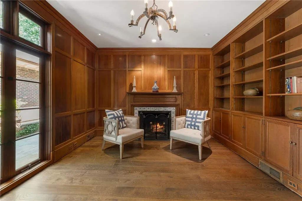 Wood-paneled room featuring a fireplace with a decorative tile surround and an integrated metal fire screen