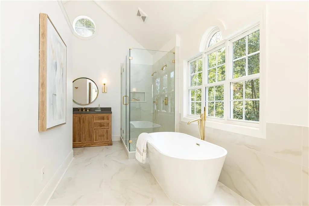 Lots of natural light shines upon the beautiful marble look tile on floors and walls