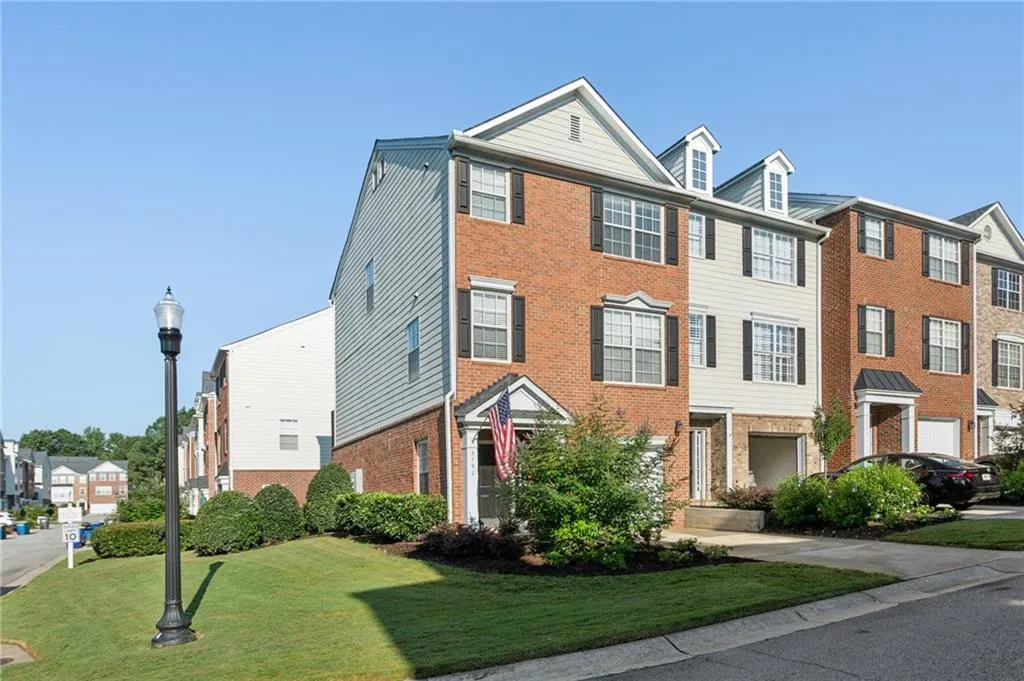 Colonial-style house with brick front and partial siding. Expansive side yard with attractive landscaping and curb appeal.