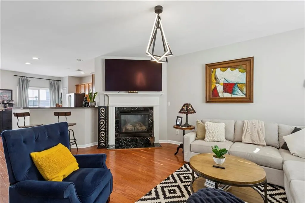 Living area with wood finished floors, a cozy fireplace, and recessed lighting