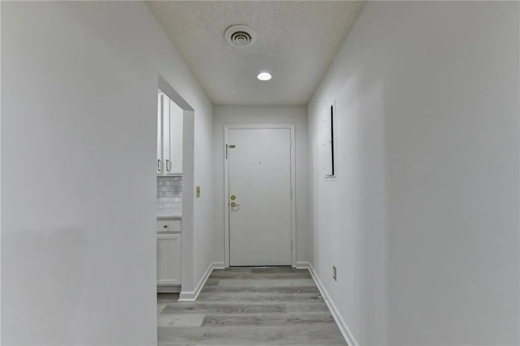 Doorway to outside featuring a textured ceiling and wood finished floors