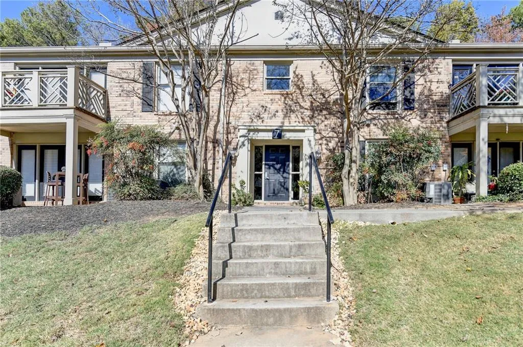 View of front facade featuring a front lawn and a balcony
