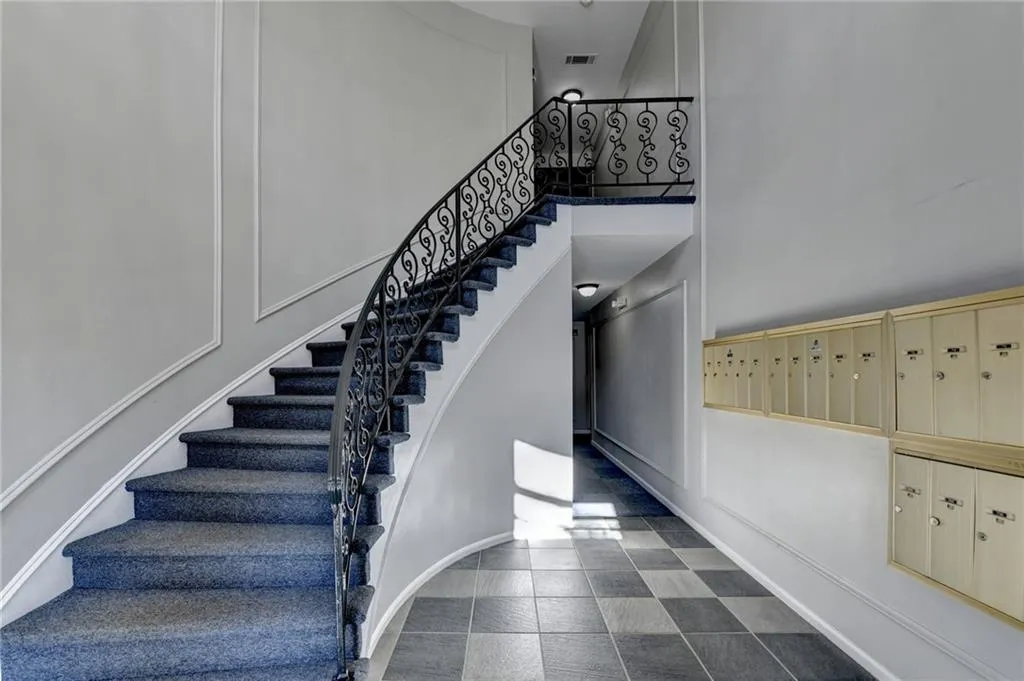 Stairway featuring mail area, a towering ceiling, and a decorative wall