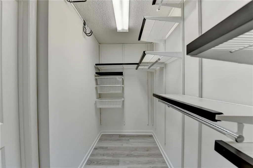 Walk in closet with light wood-type flooring