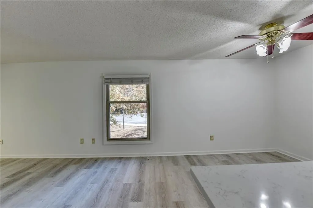 Spare room featuring a textured ceiling, light wood-type flooring, and a ceiling fan