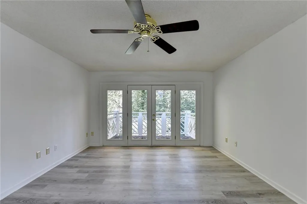 Spare room with light wood-style floors, a textured ceiling, and ceiling fan