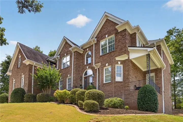Brick exterior with multiple gables, white window trim, and a covered entry