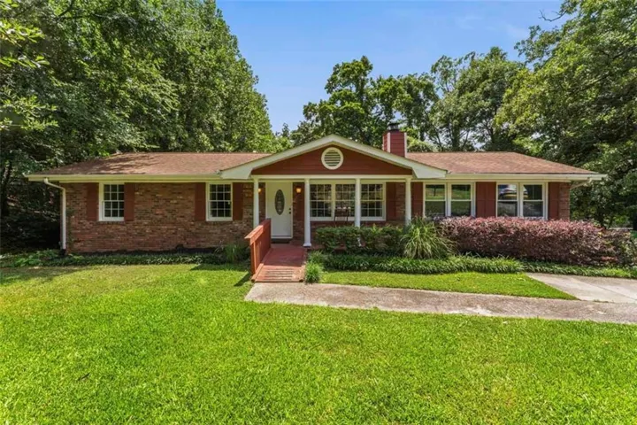 Brick facade home featuring a prominent front porch with a white entry door