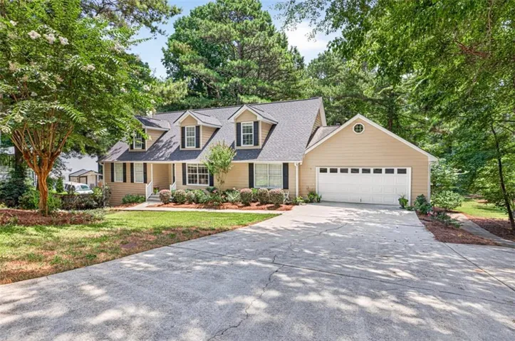 Traditional two-story residence with a two-car garage, dormer windows, and a concrete driveway