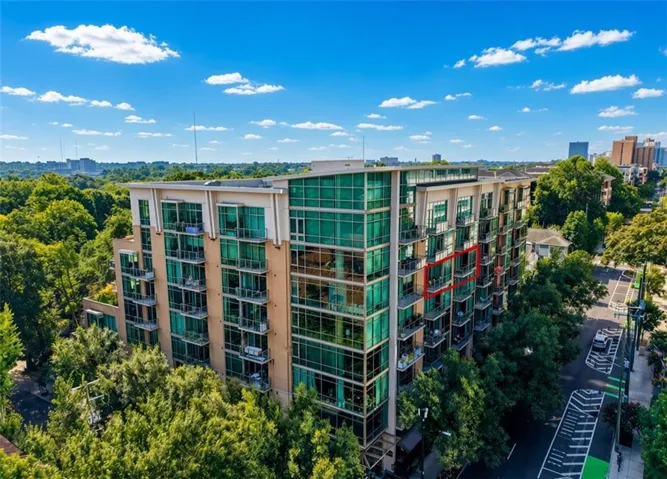 Modern multi-story building featuring multiple balconies, large windows, and a prominent street-facing facade