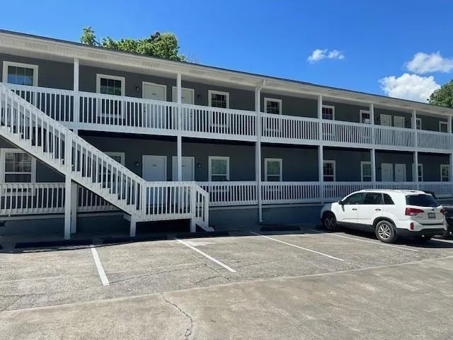View of apartment building / complex featuring uncovered parking
