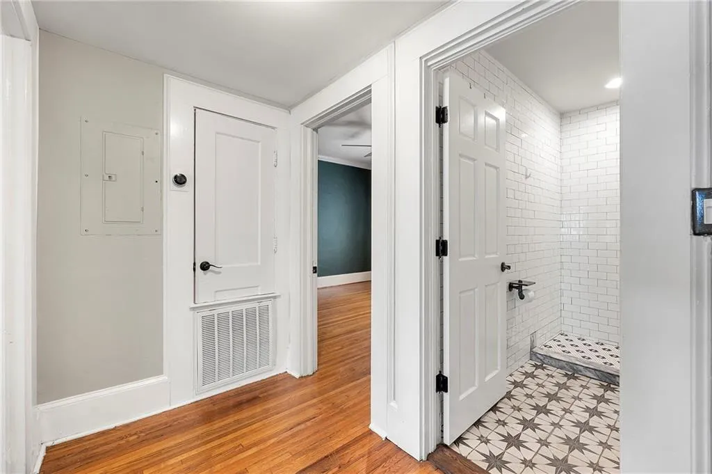 Hallway featuring light wood-type flooring, baseboards, and electric panel