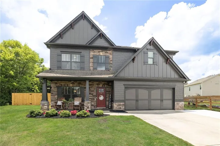Two-story residence featuring a stone and siding exterior with gabled accents