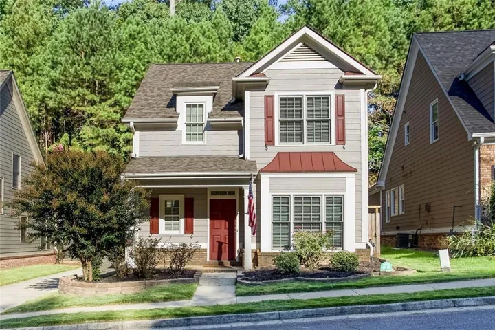 Two-story residence with gray siding, red accent shutters, and a red front door